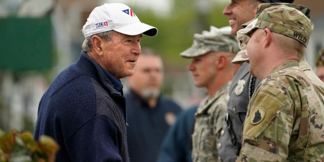 Former President George W. Bush thanks members of the American Legion Post 159 firing squad after a Memorial Day service in Kennebunkport, Maine, Monday, May 31, 2021. (AP Photo/Robert F. Bukaty)