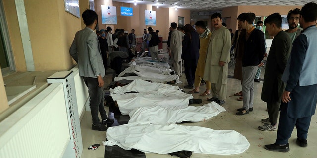 Afghan men try to identify the dead bodies at a hospital after a bomb explosion near a school west of Kabul, Afghanistan, Saturday, May 8, 2021. (Associated Press)