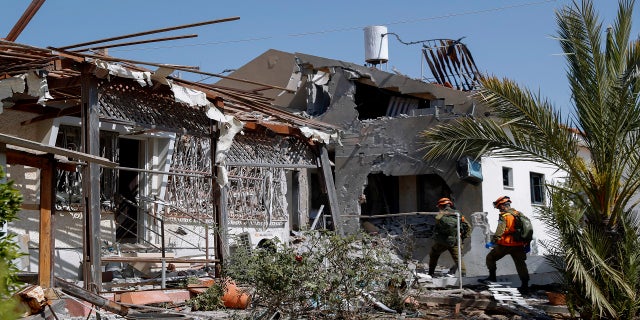 Israeli soldiers inspect a house damaged by a missile fired from the Gaza Strip in the southern Israeli city of Ashkelon on Tuesday. (AP)