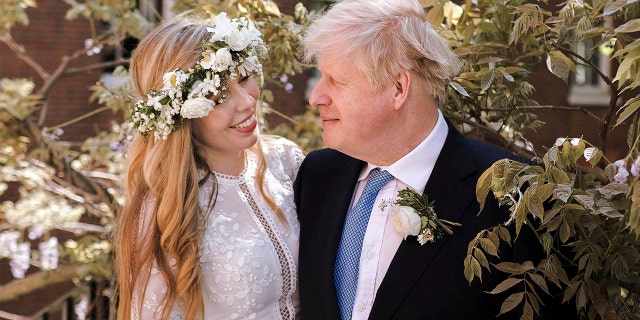 In this image released Sunday May 30, 2021, by Downing Street, Britain's Prime Minister Boris Johnson and Carrie Johnson pose together for a photo in the garden of 10 Downing Street after their wedding on Saturday. Boris Johnson and his fiancée Carrie Symonds are newlyweds, according to an announcement from his Downing Street office saying they were married Saturday May 29, in a small private ceremony in London. (Rebecca Fulton/Downing Street via AP)