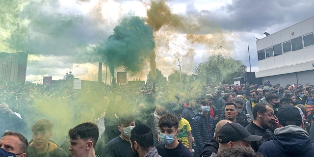 Manchester United fans hold flares as they protest outside of Old Trafford, during a protest against the Glazer family, owners of Manchester United, before their Premier League match against Liverpool at Old Trafford, Manchester, England, Sunday, May 2, 2021.