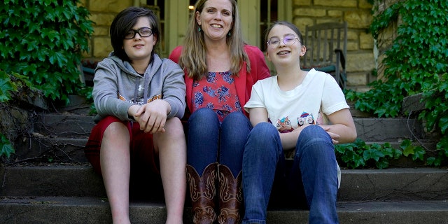 May 4, 2021: Heather Ousley, who plans to get her kids vaccinated as soon as they are eligible, sits with her older children Elliannah, 15, right, and Samuel, 13, in front of their home in Merriam, Kan.