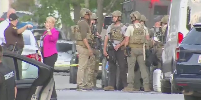Authorities in Charles County, Md., gather amid a situation with a barricaded suspect who allegedly shot two officers Monday.