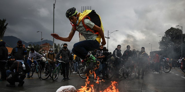 An anti-government demonstrator in skates jumps over a fire during a protest in Bogota, Colombia, Wednesday, May 5, 2021. The protests that began last week over a tax reform proposal continue despite President Ivan Duque's withdrawal of the tax plan on Sunday, May 2.  (AP Photo/Ivan Valencia)