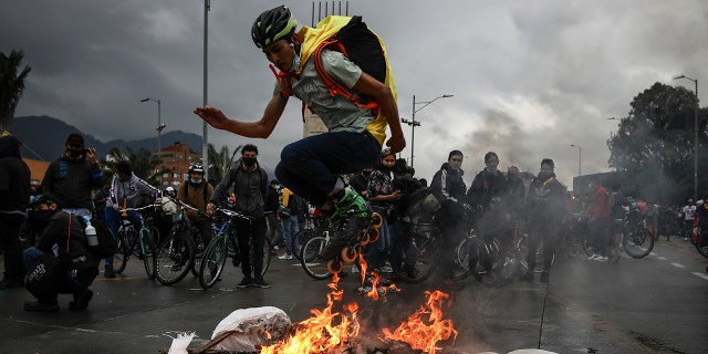 An anti-government demonstrator in skates jumps over a fire during a protest in Bogota, Colombia, Wednesday, May 5, 2021. The protests that began last week over a tax reform proposal continue despite President Ivan Duque's withdrawal of the tax plan on Sunday, May 2. (AP Photo/Ivan Valencia)
