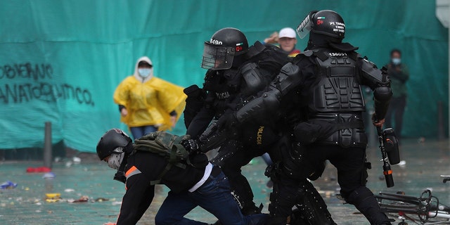 Police detain a demonstrator during an anti-government protest in Bogota, Colombia, Wednesday, May 5, 2021. The protests that began last week over a tax reform proposal continue despite President Ivan Duque's withdrawal of the tax plan on Sunday, May 2. (AP Photo/Fernando Vergara)