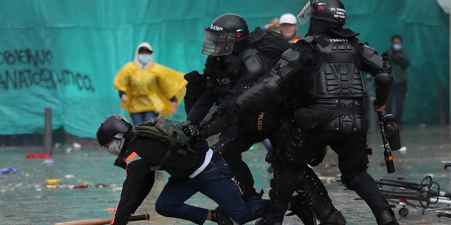 Police detain a demonstrator during an anti-government protest in Bogota, Colombia, Wednesday, May 5, 2021. The protests that began last week over a tax reform proposal continue despite President Ivan Duque's withdrawal of the tax plan on Sunday, May 2. (AP Photo/Fernando Vergara)
