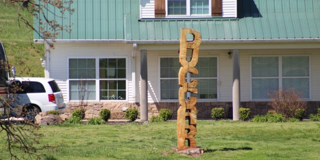 A wooden sculpture spelling out 'Duggar' is erected on the TV family's front yard.