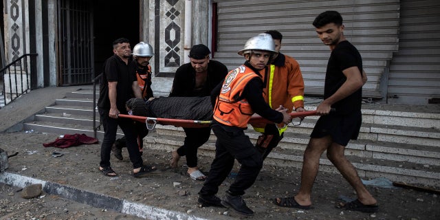 Palestinian rescuers evacuate an elderly woman from a building following Israeli airstrikes on Gaza City on Wednesday.