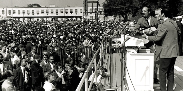American folk and pop group Peter, Paul and Mary perform during the March on Washington for Jobs and Freedom, Washington DC, August 28, 1963. The trio behind the microphone features, from left, Paul Stookey, Mary Travers (1936 - 2009), and Peter Yarrow. The march and rally provided the setting for the Reverend Martin Luther King Jr's iconic 'I Have a Dream' speech. 