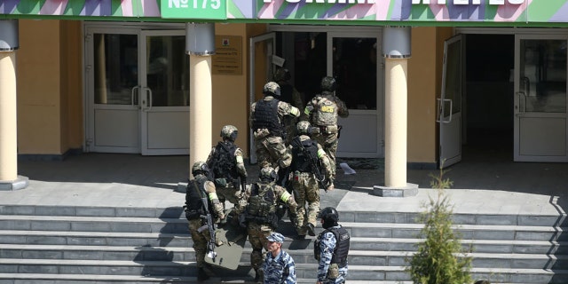 Officers by the Russian school where two attackers reportedly opened fire on May 11, 2021. (Photo by Yegor AleyevTASS via Getty Images)
