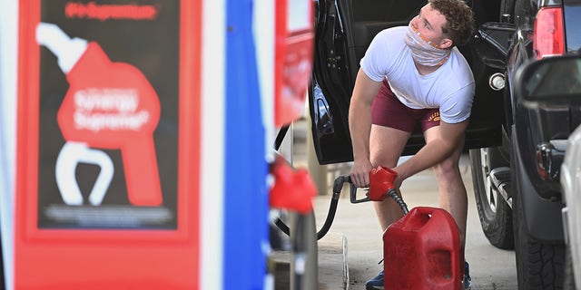 A man fills up a gas container after filling up his vehicle at an Exxon gas station on Wednesday, May 12, 2021, in Springfield, Virginia.