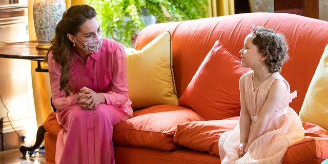 Catherine, Duchess of Cambridge meets Mila Sneddon, aged five, and her family, at the Palace of Holyroodhouse on May 27, 2021, in Edinburgh, Scotland. Cancer patient Mila features in an image from the Hold Still photography project which showed her kissing her father Scott through a window whilst she was shielding during her chemotherapy treatment.