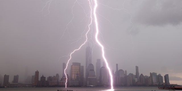 Jersey City, New Jersey - JULY 6: Two lightning bolts frame One World Trade Center as they hit the Hudson River in front of the skyline of lower Manhattan in New York City during a thunderstorm on July 6, 2020 as seen from Jersey City, New Jersey. (Photo by Gary Hershorn/Getty Images)