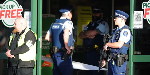 Police officers are observed standing guard outside the main entrance of the Dunedin Central Countdown on May 10, 2021, in Dunedin, New Zealand. (Photo by Joe Allison/Getty Images)