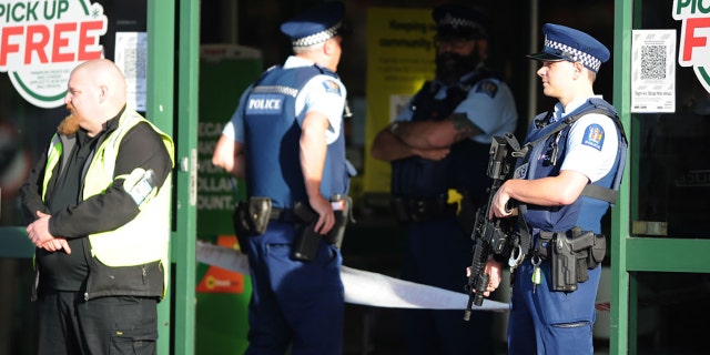 Police officers are observed standing guard outside the main entrance of the Dunedin Central Countdown on May 10, 2021, in Dunedin, New Zealand. (Photo by Joe Allison/Getty Images)