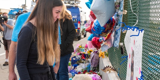 Alexis Cloonan, suster van die 6-jarige Aiden Leos, cries at the memorial erected on freeway overpass in Orange, Kalifornië, op Dinsdag, Mei 25, 2021. (Getty Images)