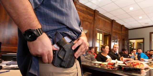 Damon Thueson shows holster to a concealed weapon license class set up by "Firearms training in the United States" in Provo, Utah.  (Photo by George Frey / Getty Images)