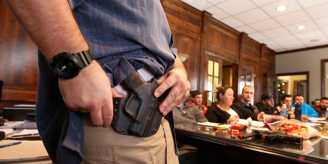 Damon Thueson shows a holster at a gun concealed carry permit class put on by "USA Firearms Training" on Dec. 19, 2015 in Provo, Utah.