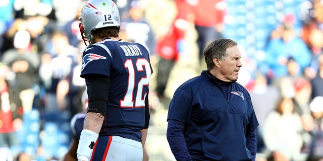 New England Patriots' Tom Brady No.12 and head coach Bill Belichick watch during warm-ups before the AFC Championship game against the Jacksonville Jaguars at Gillette Stadium on January 21, 2018 in Foxborough, Massachusetts.  