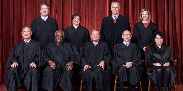 A photo of the nine sitting Supreme Court justices on April 23, 2021. Seated from left, Justices Samuel A. Alito, Jr. and Clarence Thomas, Chief Justice John G. Roberts Jr., and Justices Stephen G. Breyer and Sonia Sotomayor. Standing from left, Justices Brett M. Kavanaugh, Elena Kagan, Neil M. Gorsuch and Amy Coney Barrett.