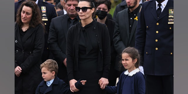 Irene Tsakos holds the hands of her children as she watches NYPD officers fold an American flag that draped the casket of her husband NYPD Officer Anastasios Tsakos during his funeral service at St. Paraskevi Greek Orthodox Shrine Church on May 04, 2021 in Greenlawn, New York.