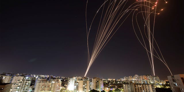 Streaks of light are seen as Israel's Iron Dome anti-missile system intercepts rockets launched from the Gaza Strip, as seen from Ashkelon, Israel, May 11, 2021.
