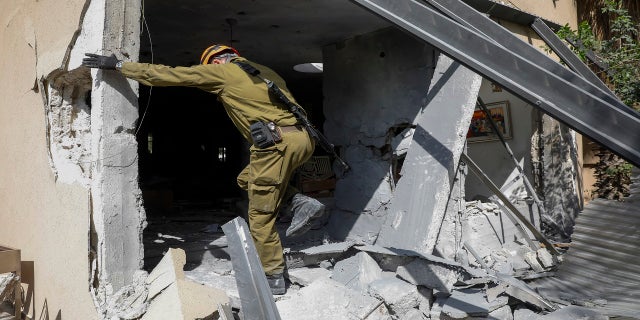 An Israeli soldier inspects a damaged house after being struck by a rocket fired from the Gaza Strip in Ashkelon, Israel, Thursday. (AP)