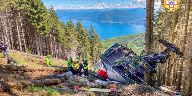 Rescuers work by the wreckage of a cable car after it collapsed near the summit of the Stresa-Mottarone line in the Piedmont region, northern Italy, on Sunday.