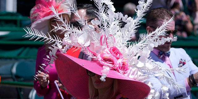 A women watches a race before the 147th running of the Kentucky Oaks at Churchill Downs, Friday, April 30, 2021, in Louisville, Ky.(AP Photo/Michael Conroy)