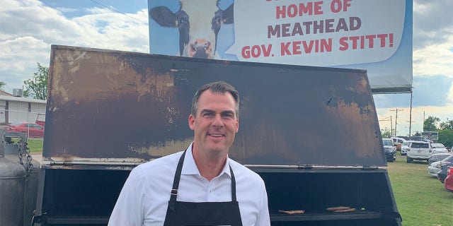 Oklahoma Gov. Kevin Stitt (R) hosts a meat cookout beneath a pro-vegan billboard criticizing him on May 12, 2021, in Oklahoma City.