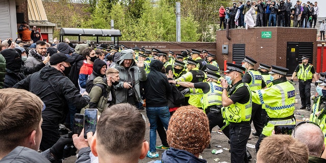 OLD TRAFFORD, MANCHESTER, UNITED KINGDOM - 2021/05/02: Police officers move in to disperse football fans during a protest against the Glazer's ownership of Manchester United.