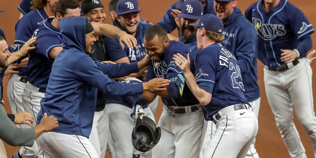 Tampa Bay Rays' Manuel Margot, center, is congratulated by teammates after his game-winning single against the Kansas City Royals during the 10th inning of a baseball game Wednesday, May 26, 2021, in St. Petersburg, Fla. The Rays won 2-1.