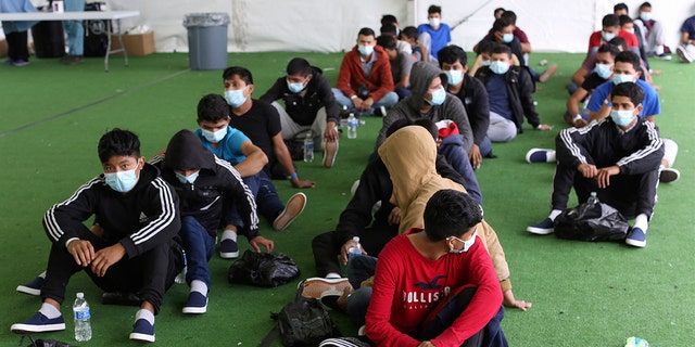 In this March 30, 2021, file photo, young migrants wait to be tested for COVID-19 at the Donna Department of Homeland Security holding facility, the main detention center for unaccompanied children in the Rio Grande Valley in Donna, Texas. 