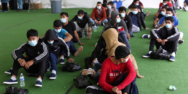 In this March 30, 2021, file photo, young migrants wait to be tested for COVID-19 at the Donna Department of Homeland Security holding facility, the main detention center for unaccompanied children in the Rio Grande Valley in Donna, Texas. 