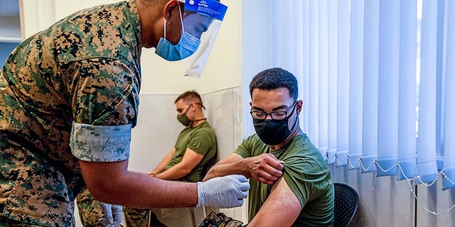 یک تفنگدار دریایی ایالات متحده برای دریافت واکسن کرونا مدرنا در کمپ هانسن در 28 آوریل 2021 در کین ژاپن آماده می شود.