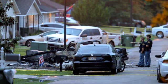 Hattiesburg police surround a burned automobile and a damaged home after a small plane crashed late Tuesday night in Hattiesburg, Miss. (AP/The Advocate)