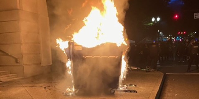 Marchers in Portland on Tuesday lit a dumpster on fire.