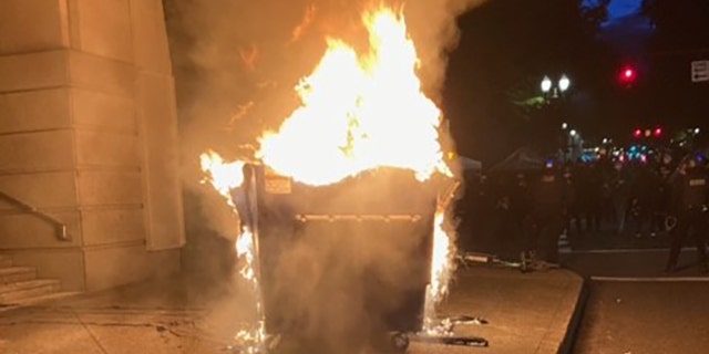 Marchers in Portland on Tuesday lit a dumpster on fire.
