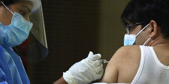 Feb. 8, 2021: A man receives his Sinopharm COVID-19 vaccine from a medical staffer at Guru Nanak Darbar temple in Dubai, United Arab Emirates.