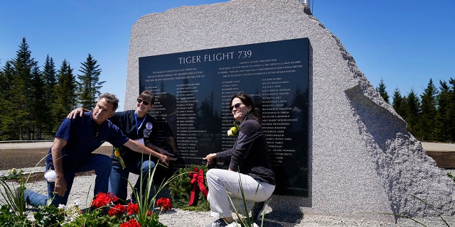 John Williams, of Peru, Indiana, left, and his sisters, Maria McCauley, of Branson, Missouri, center, and Susie Linale, of Omaha, Nebraska, pose at a monument to honor the military passengers of Flying Tiger Line Flight 739, Saturday, May 15, 2021, in Columbia Falls, Maine. Their father, SFC Albert Williams, Jr., was among those killed on the secret mission to Vietnam in 1962. (Associated Press)