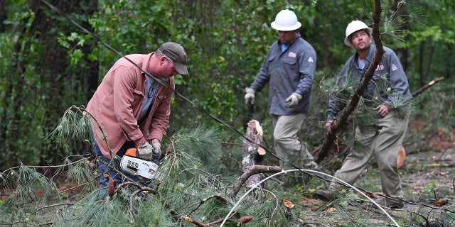 A Tupelo Water and Light crew works to clear downed trees and power lines along Oakview Drive in Tupelo, Miss., Monday, May 3, 2021. (AP Photo/Thomas Graning)