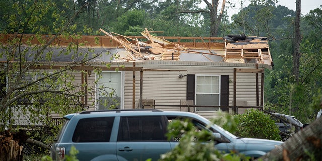 A roof of a home is missing on Ford Road in Byram, Mississippi, on Monday, May 3, 2021, after a tornado touched down in the area Sunday night. 