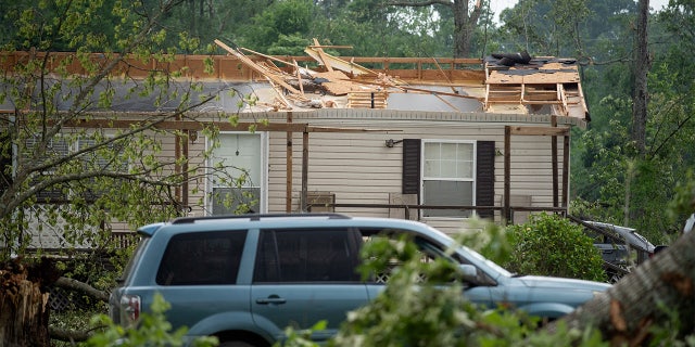 A roof of a home is missing on Ford Road in Byram, Mississippi, on Monday, May 3, 2021, after a tornado touched down in the area Sunday night.
