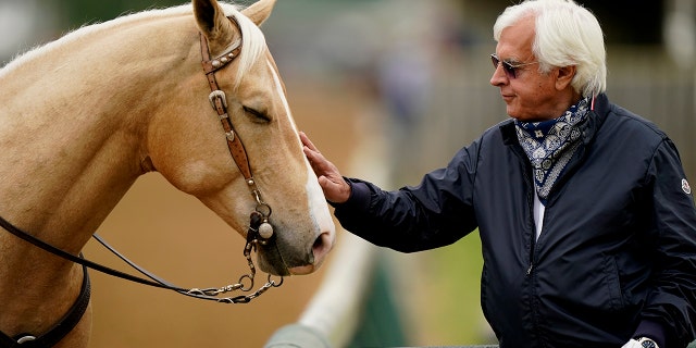 Trainer Bob Baffert pets an outrider's horse while watching workouts at Churchill Downs Wednesday, April 28, 2021, in Louisville, Ky. The 147th running of the Kentucky Derby is scheduled for Saturday, May 1. (WHD Photo/Charlie Riedel)