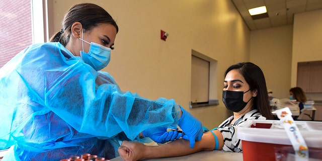 Phlebotomist Briana Green draws blood from Maritza Nieves during the new FDA emergency use and authorized IgG ll Antibody Test for vaccinated people, offered free of charge in Santa Fe Springs, Kalifornië, op April 21, 2021. (FREDERIC J. BROWN/AFP via Getty Images)