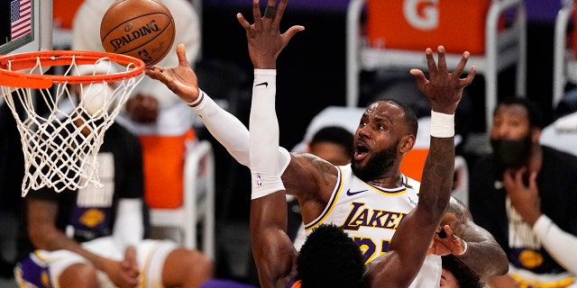 Los Angeles Lakers forward LeBron James, top, shoots as Phoenix Suns center Deandre Ayton defends during the second half in Game 4 of an NBA basketball first-round playoff series Sunday, May 30, 2021, in Los Angeles. (AP Photo/Mark J. Terrill)