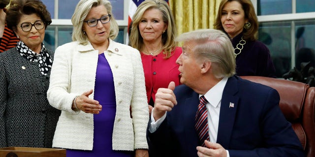 In this Nov. 25, 2019, file photo, Rep. Liz Cheney, R-Wyo., center, speaks with President Donald Trump during a bill signing ceremony for the Women's Suffrage Centennial Commemorative Coin Act in the Oval Office of the White House in Washington.