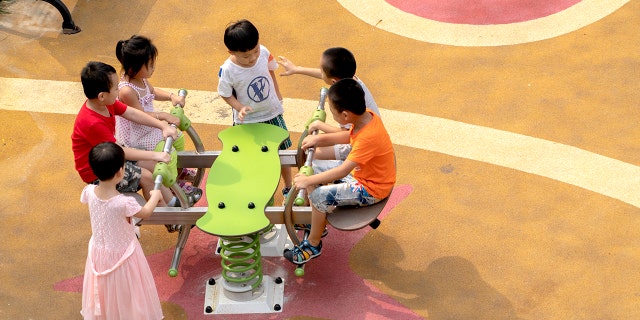 Kids are seen playing in a playground in a residential district. Though China tried to encourage young couple have more than one baby, the birth rate keeps decreasing in recent years. (Photo by Zhang Peng/LightRocket via Getty Images)
