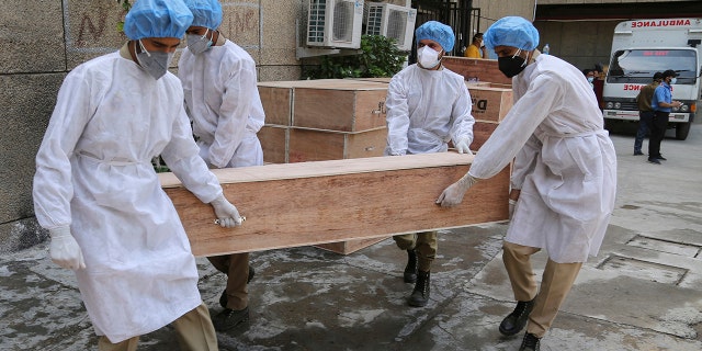 May 19, 2021: Jammu and Kashmir State Disaster Response Force soldiers carry empty coffins for transporting bodies of people who died of COVID-19 outside government medical hospital in Jammu, India.